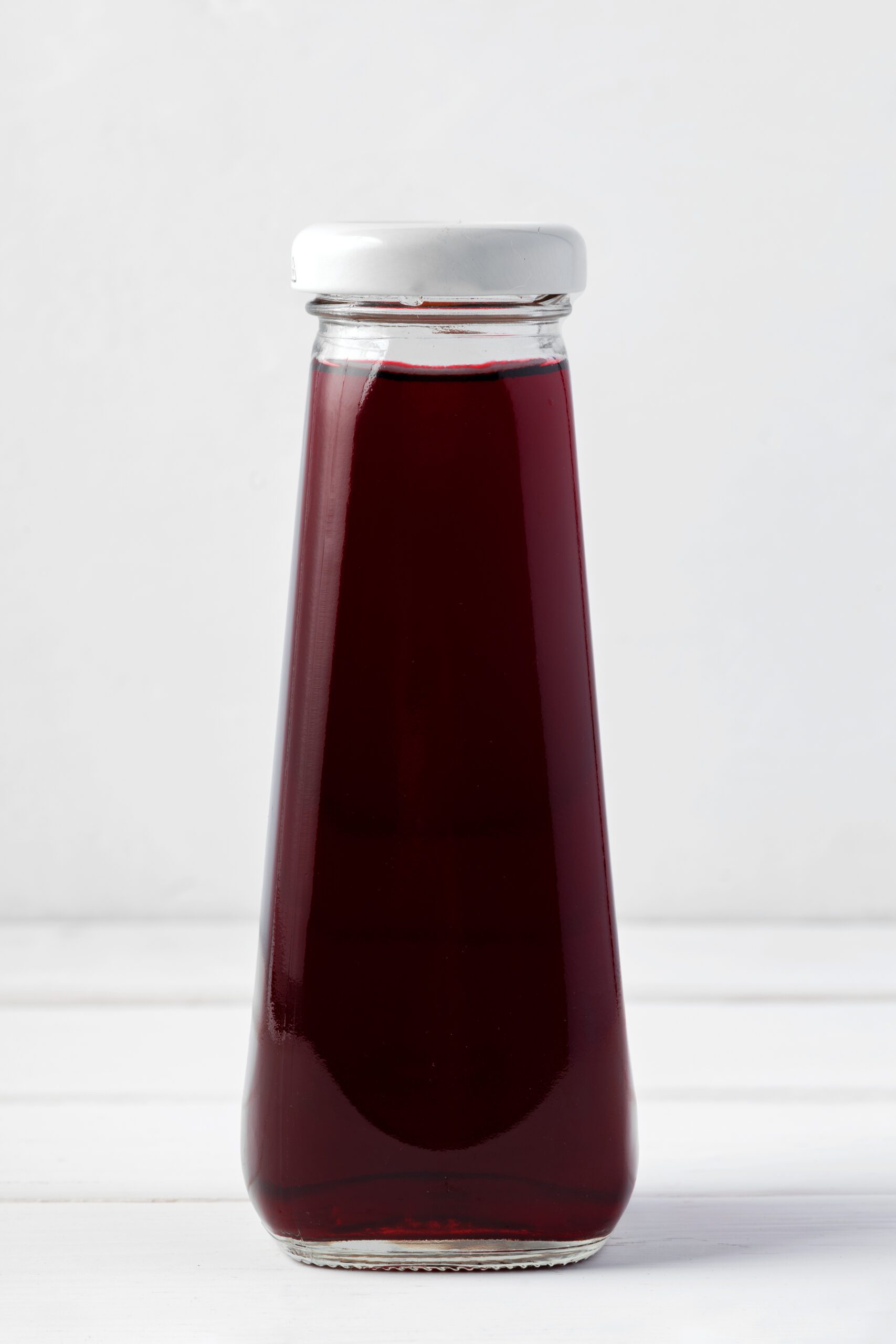 Small glass bottle of fresh juice on white background Hibiscus Lemonade - Image 1