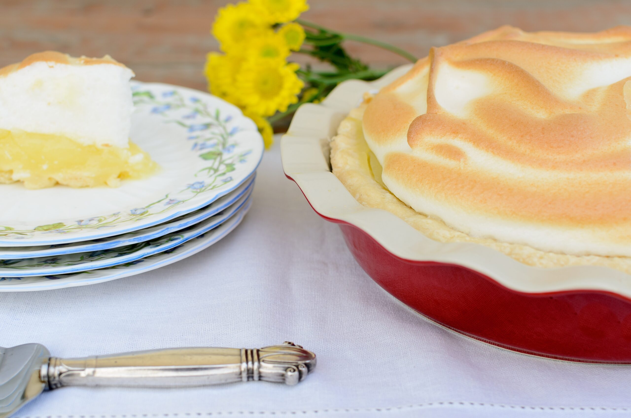 delicious-lemon-meringue-pie-with-flowers-on-table-2026-03-15-23-21-22-utc Gluten-Free Lemon Meringue Pie - Image 1